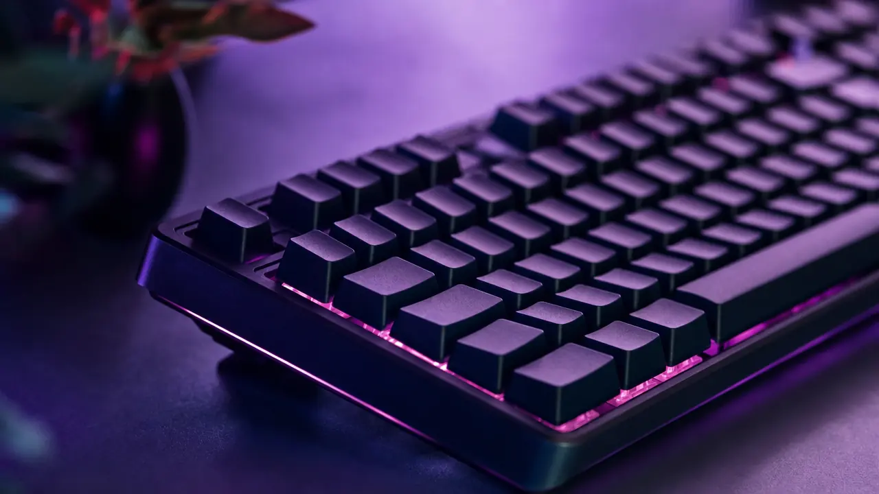 A backlit mechanical keyboard in magenta and violet light